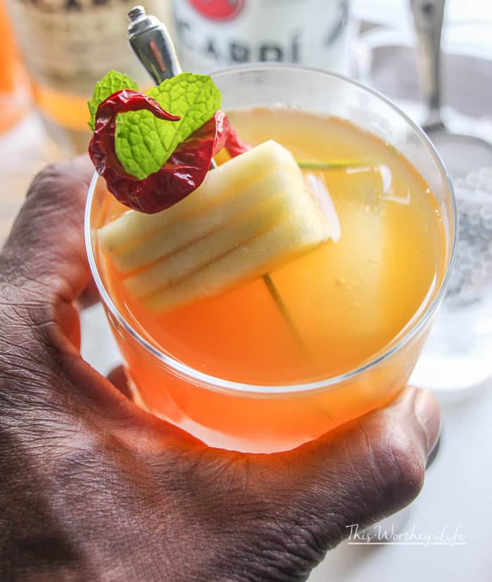 man's hand holding a rum + apple cider cocktail