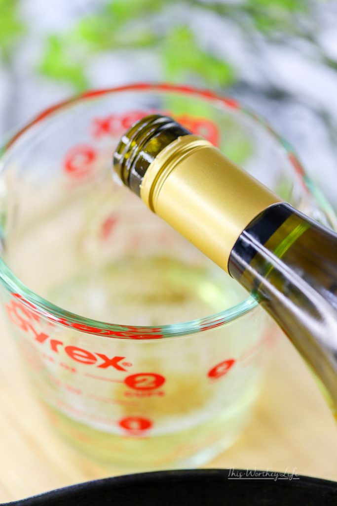 pouring white wine into a measuring glass