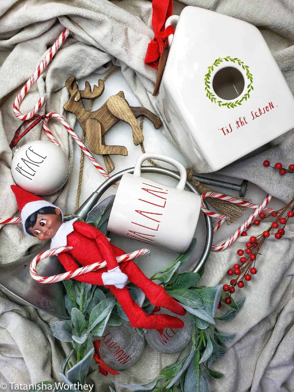black elf on the shelf holding a peppermint stick