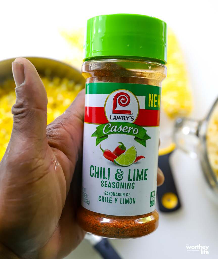 a man holding chili and lime seasoning