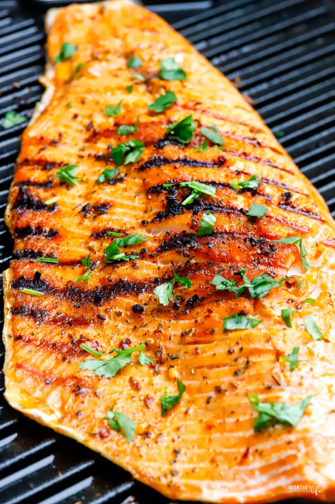 large slab of salmon laying cooked on grill