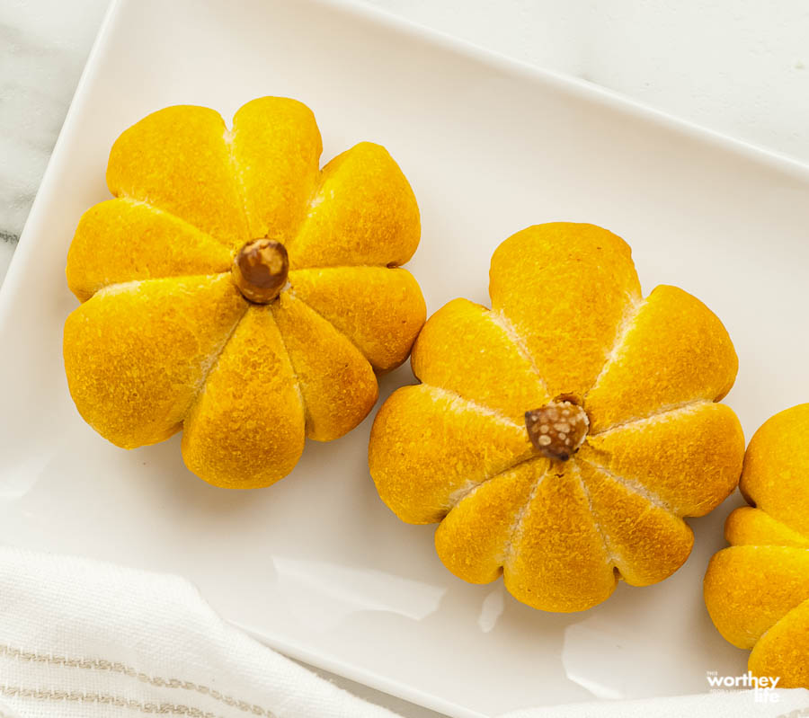 storing pumpkin dinner rolls on white plate