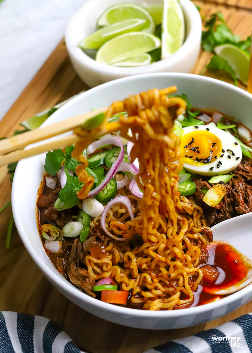 Birria Pork Ramen with chopsticks.