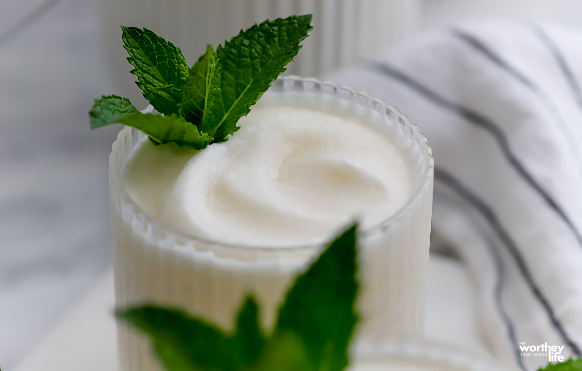 A partial view of our frozen coconut margarita garnished with fresh mint.