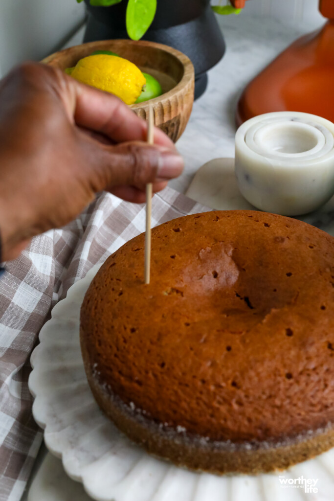 a man poking holes in a cake to fill with glaze