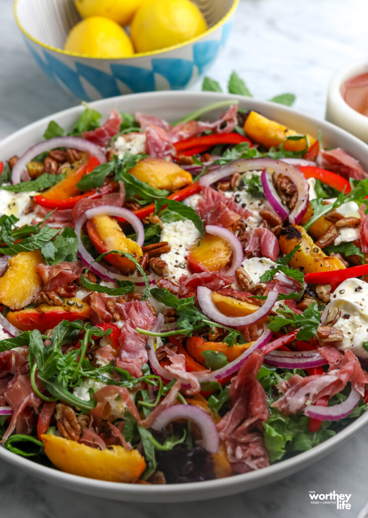 peach prosciutto burrata salad in a big mixing salad bowl 