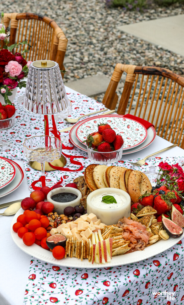 a place setting with strawberries and breakfast board