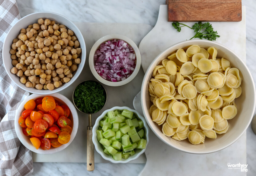 ingredients to make a Mediterranean Chickpea salad in small white bowls