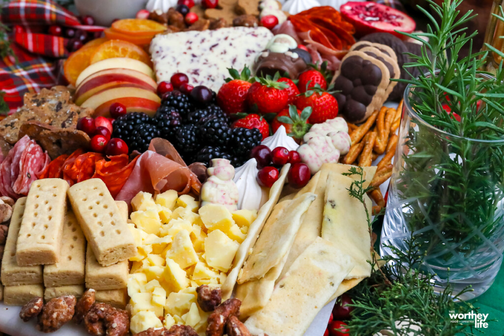 a board full of meats and cheeses for a holiday board
