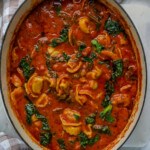 Creamy Tomato, Sausage, Kale, and Tortellini Soup in a blue dutch oven