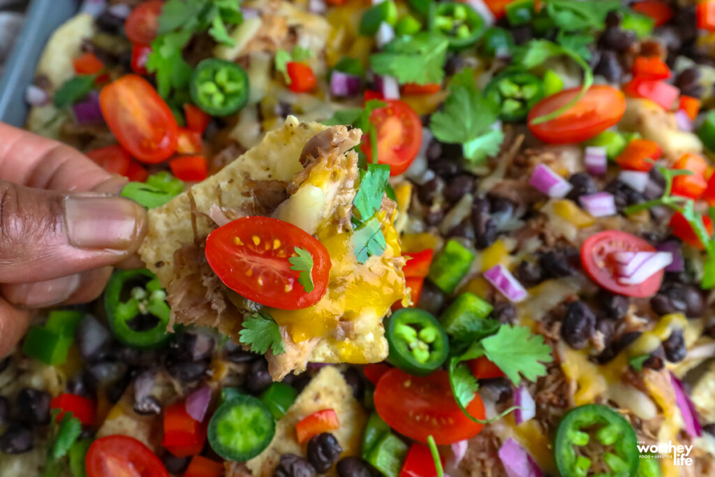 a man holding carnita nachos i