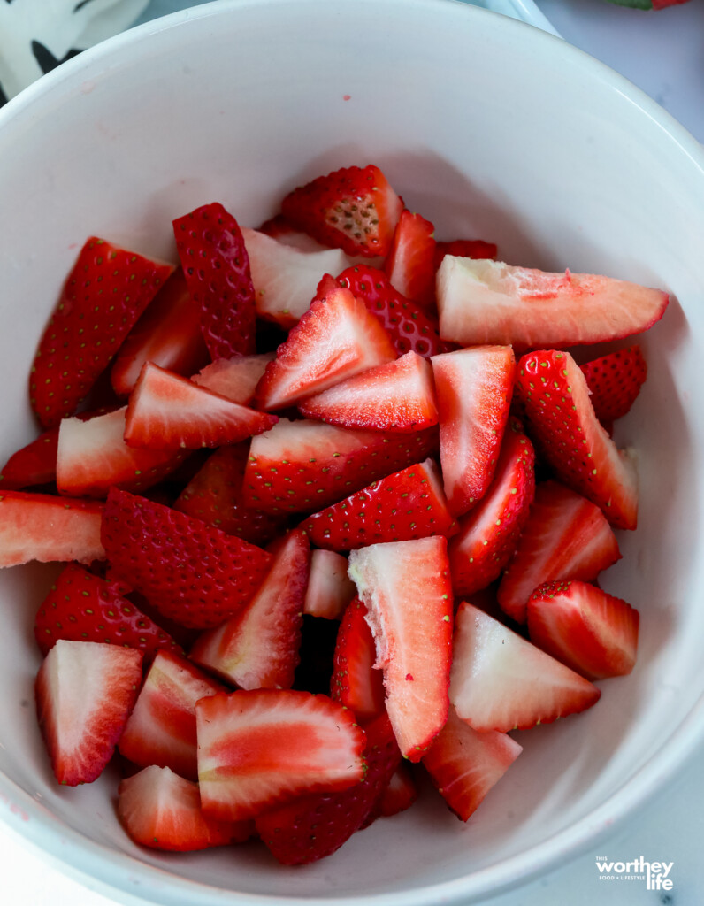 making macerated strawberries in a white bowl