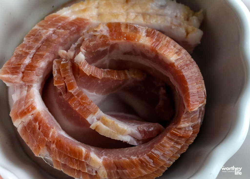 thick cut bacon rolled in a white bowl