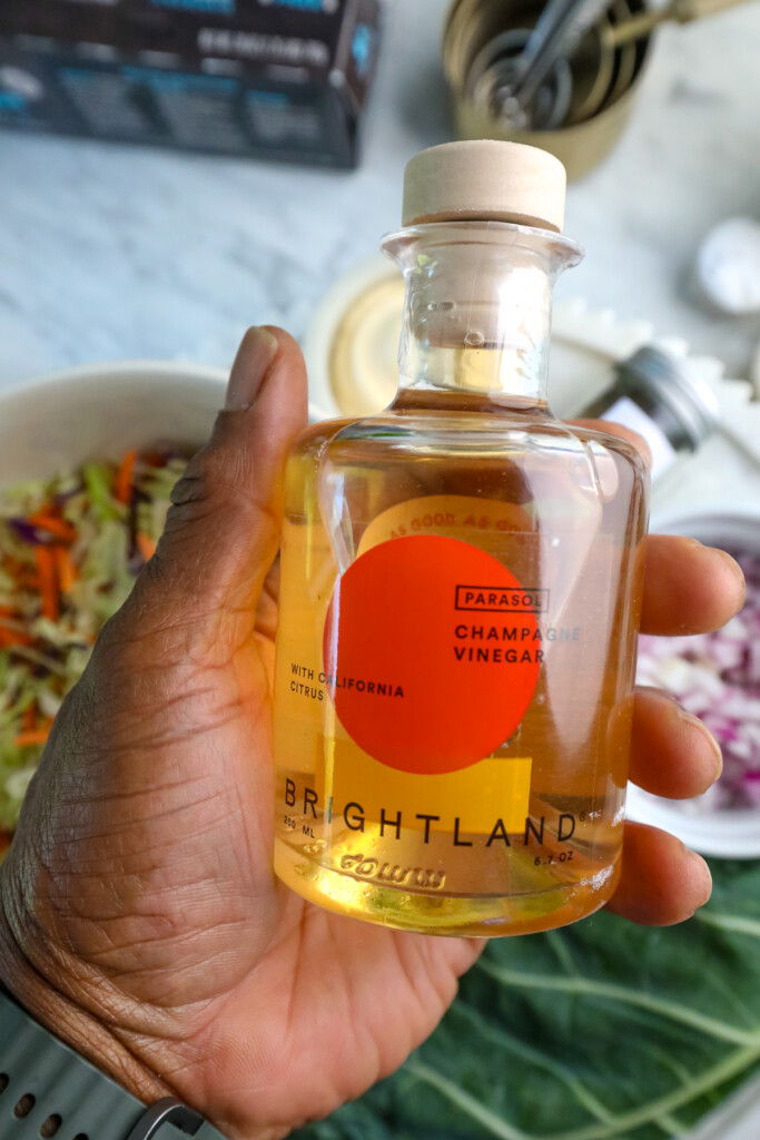 man holding a bottle of brightland's Champagne Vinegar