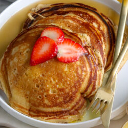 stacks of brown sugar pancakes with strawberries on top
