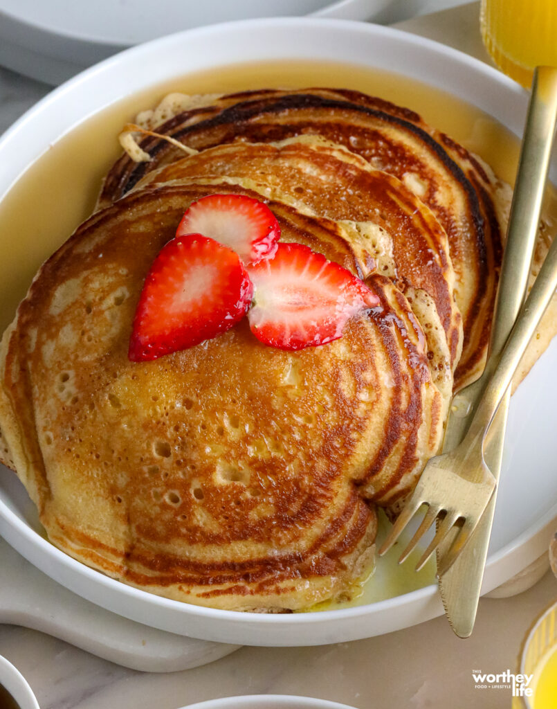 stacks of brown sugar pancakes with strawberries on top
