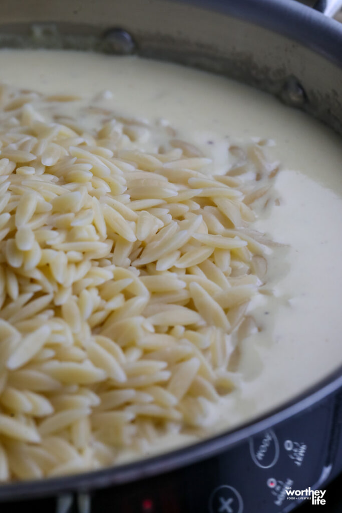 creamy orzo pasta in a skillet