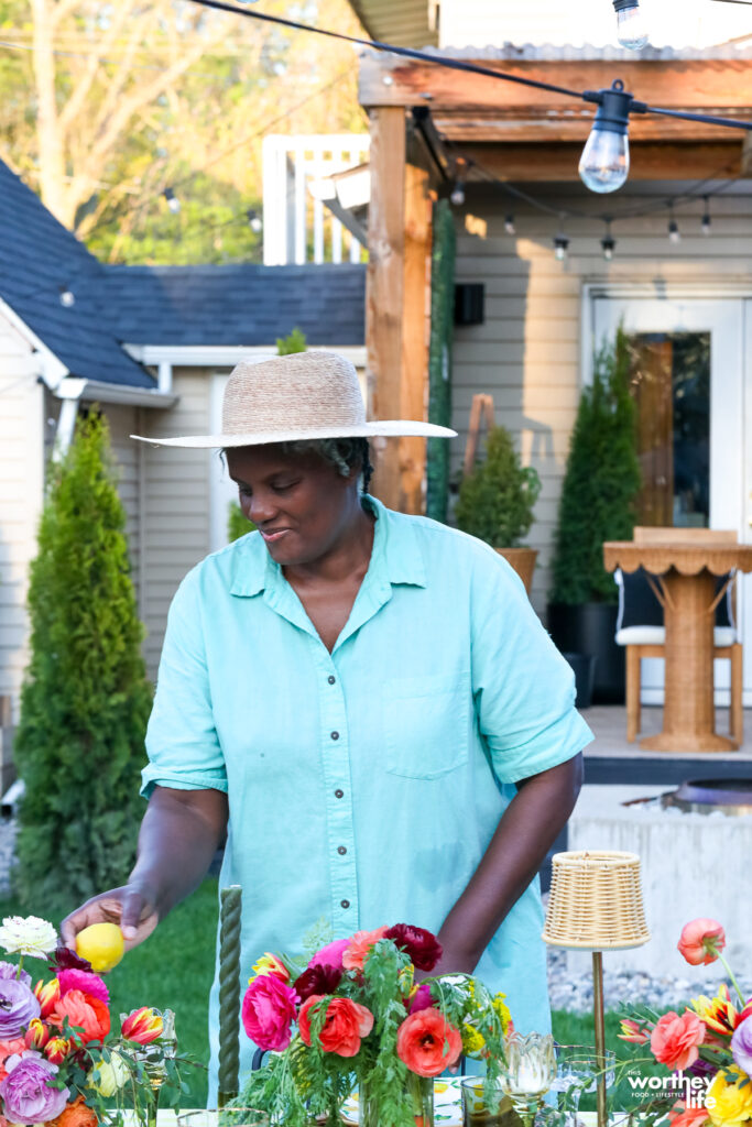 a woman setting a spring tablescape for a dinner party
