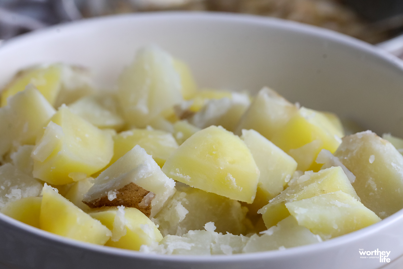 cubed potatoes in a white large bowl