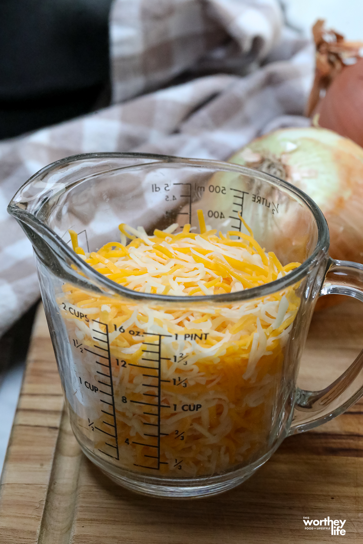 a measuring cup full of shredded cheeese