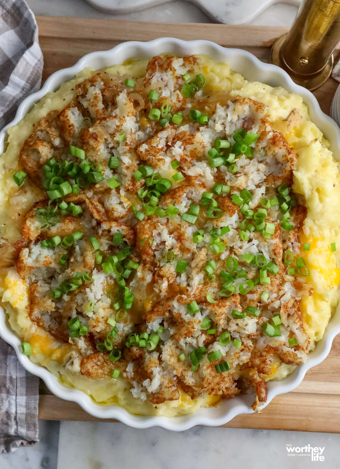These Hashbrown Mashed Potatoes combine creamy, cheesy potatoes with crispy hash browns, sweet onions and cheddar cheese for an easy crowd-pleasing side dish.